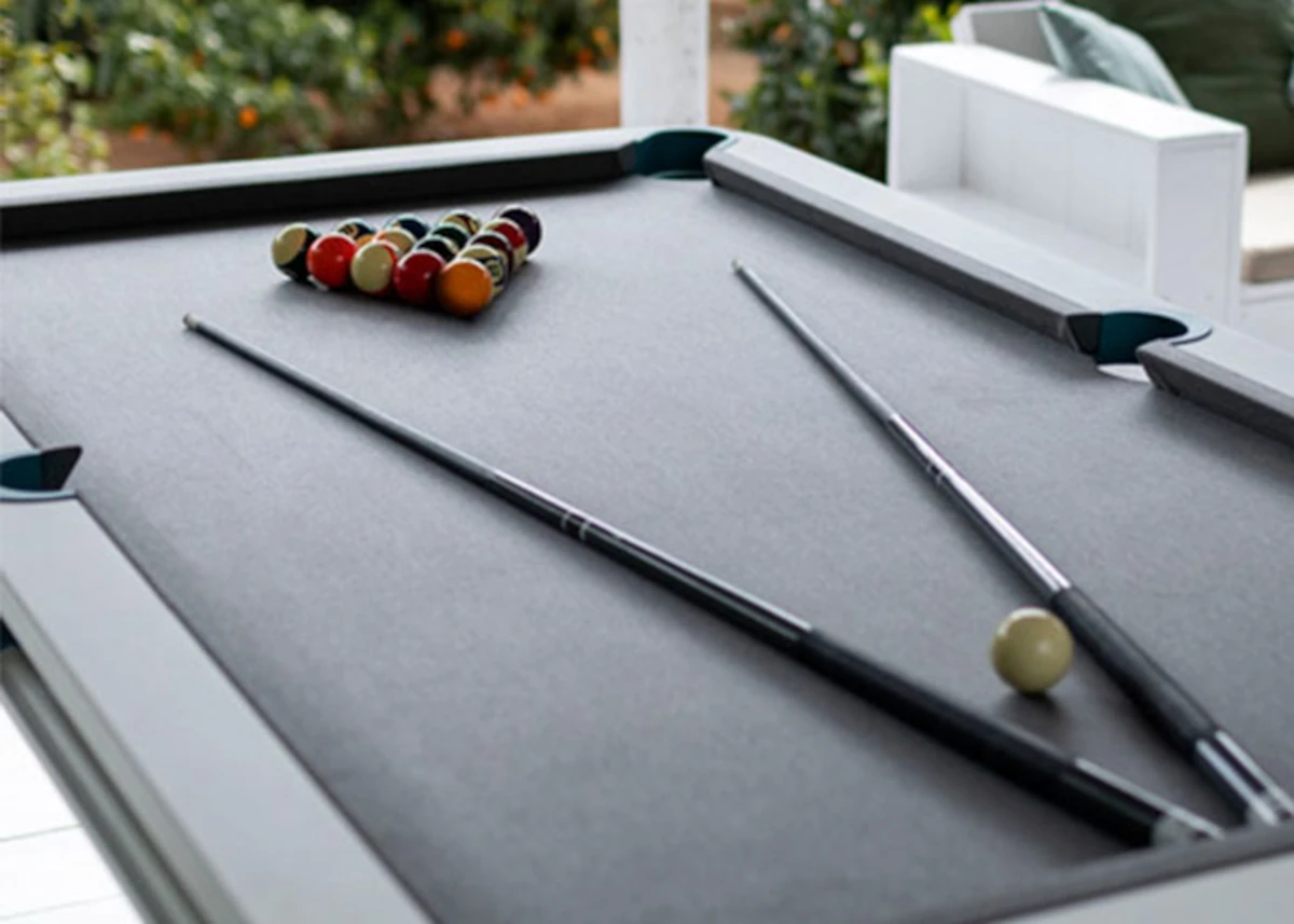 Billard Cornilleau avec tapis gris, queues de billard et boules positionnées pour commencer une partie.