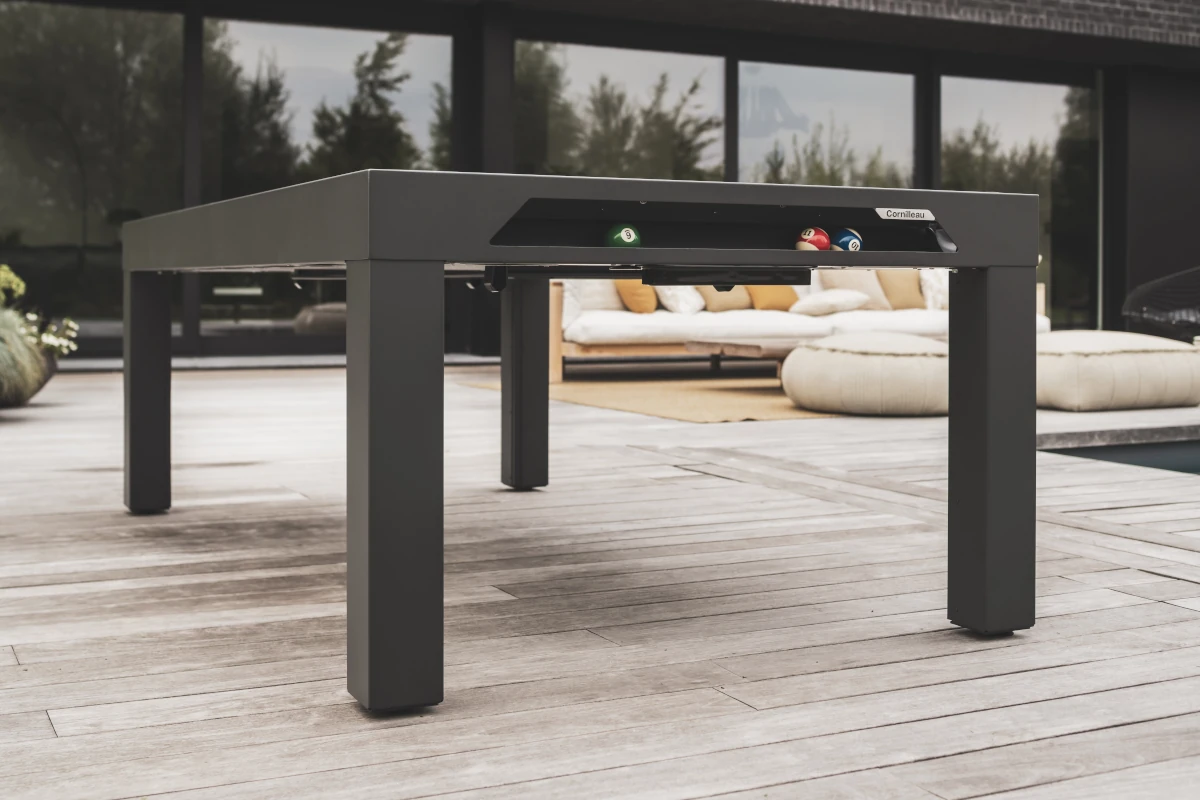 Billard Cornilleau noir installé sur une terrasse contemporaine avec rangement intégré pour les billes.