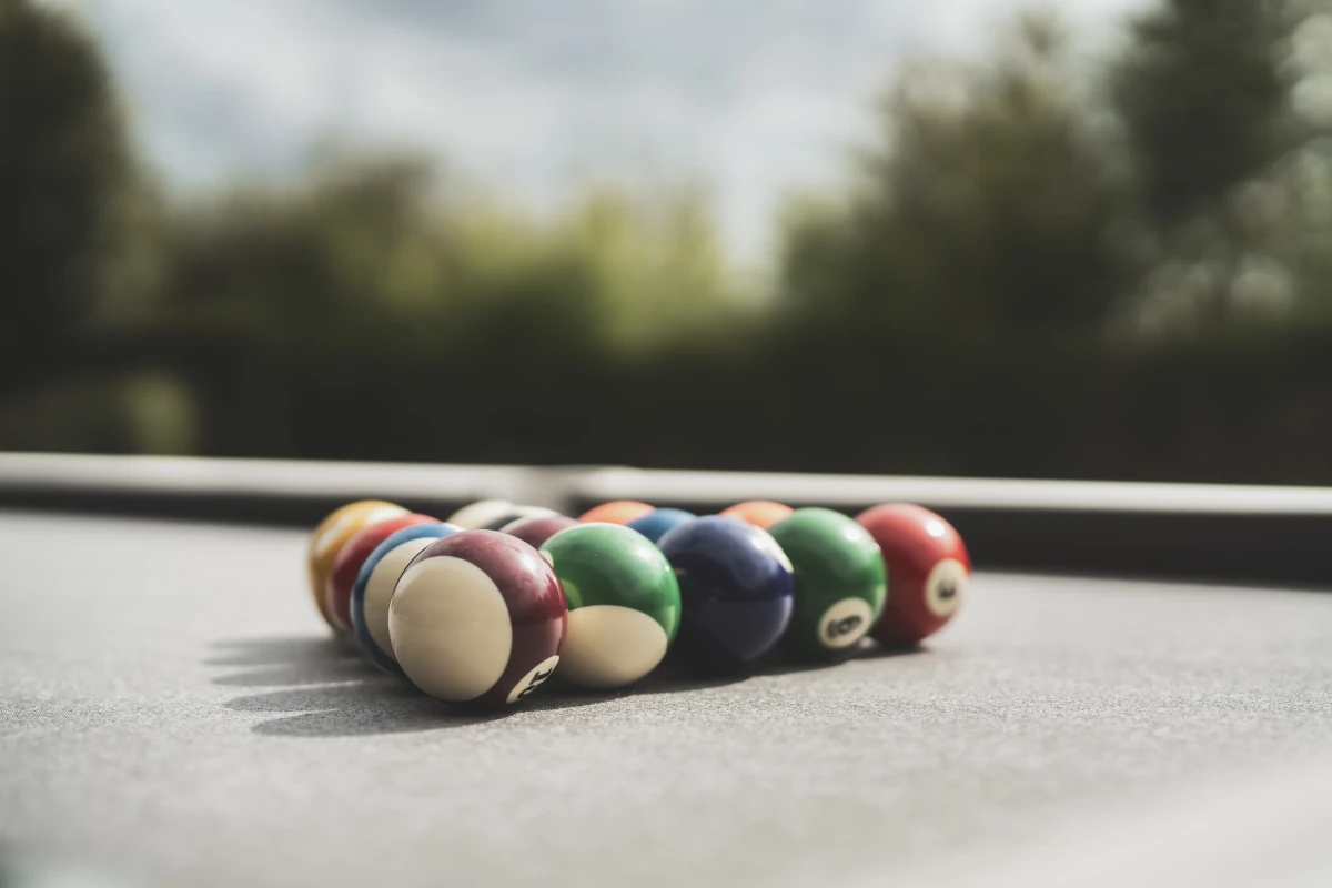 Billes de billard Cornilleau sur un tapis de jeu en extérieur