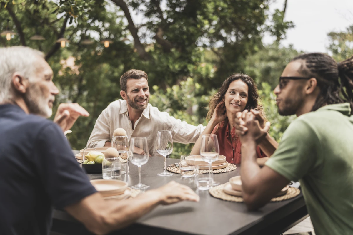 Famille réunie autour d'un billard convertible utilisé comme table de repas en terrasse.