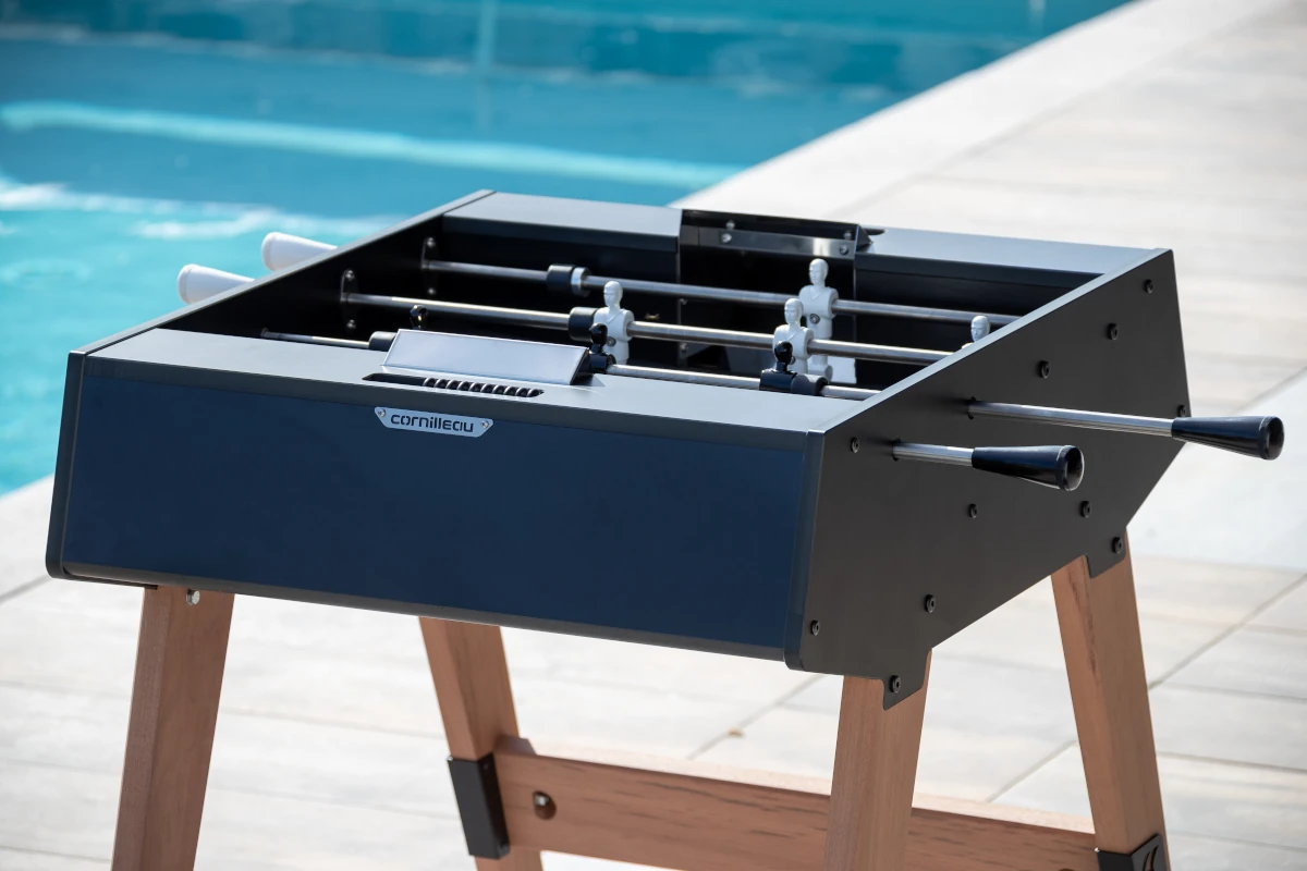 Baby-foot Cornilleau noir installé au bord d'une piscine