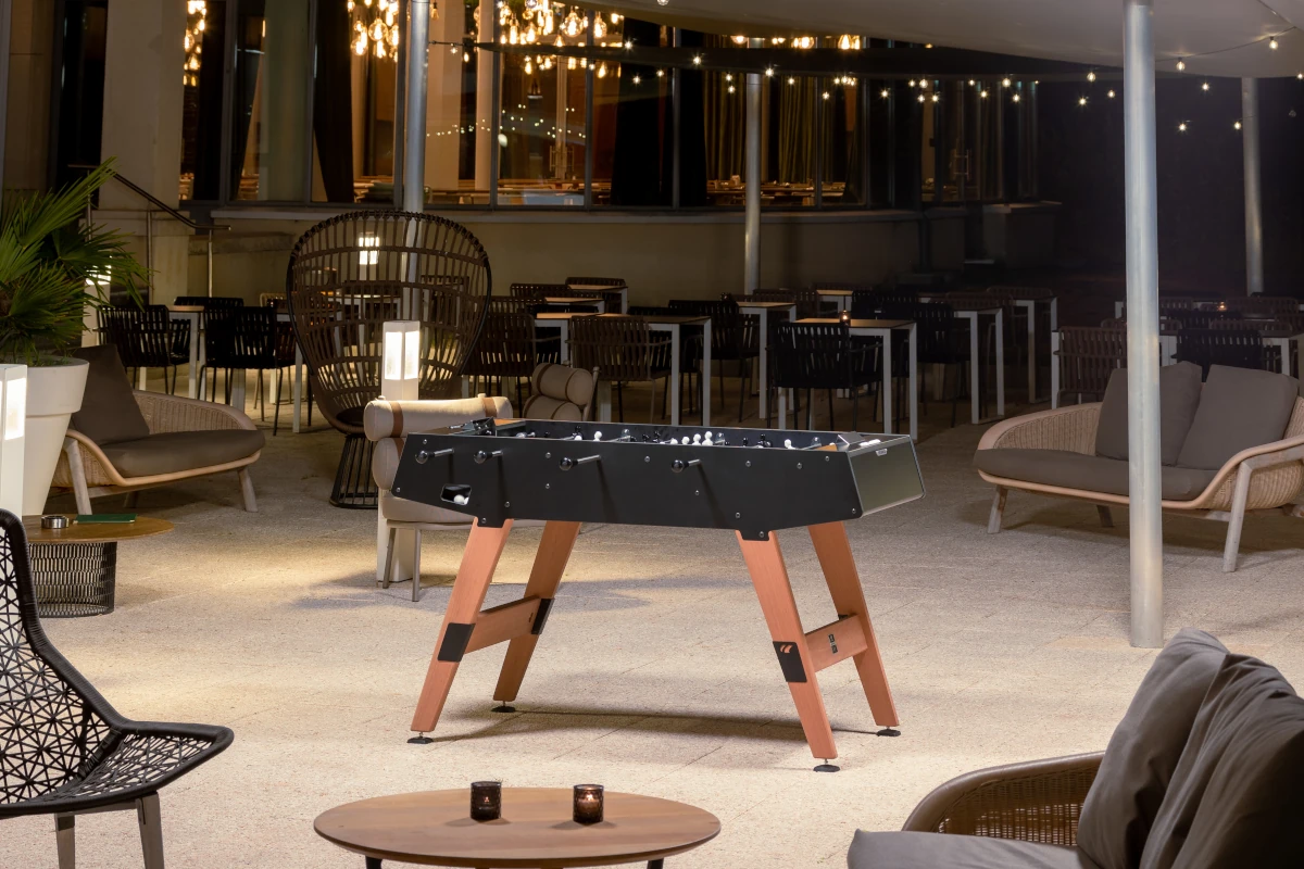 Baby-foot Cornilleau noir sur la terrasse d'un hôtel en soirée