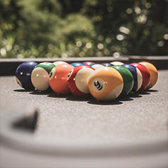 Billes de billard regroupées sur un tapis gris en extérieur